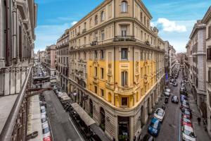 un bâtiment jaune dans une rue d'une ville dans l'établissement Suitedreams, à Rome