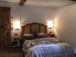 una camera da letto con un letto con due luci sul muro di APPARTAMENT La locanda nel bosco a Mezzana