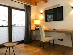 Zimmer mit einem Schreibtisch, einem TV und einem Stuhl in der Unterkunft Apartments Angela in Fieberbrunn