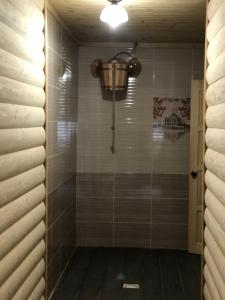 a bathroom with a shower with a light on the wall at Приватна садиба SHAFRAN in Yablunytsya +42 photos