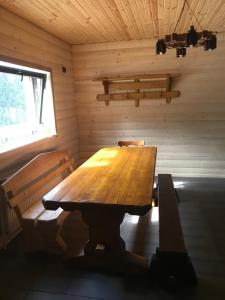 a wooden table and two benches in a cabin at Приватна садиба SHAFRAN in Yablunytsya