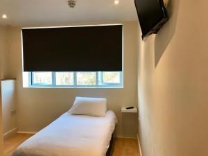 a bedroom with a bed and a tv at Eazzzy Rooms Corby in Corby