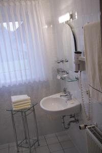 a white bathroom with a sink and a mirror at Hotel Edel in Haibach