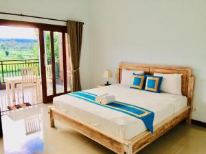 a bedroom with a bed with a balcony at D'uma Amed Homestay in Amed