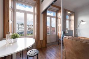 Cette chambre dispose d'une table et de fenêtres. dans l'établissement Fontainhas Design Apartment by DA'HOME, à Porto