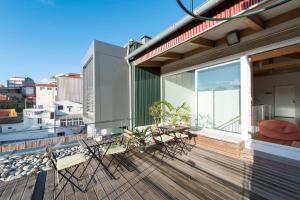 Un balcón con sillas y mesas en un edificio en Fontainhas Design Apartment by DA'HOME, en Oporto