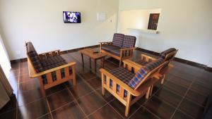 a waiting room with chairs and a table and a tv at Jock-Sabie Lodge in Sabie