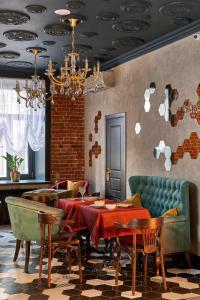 a dining room with a table and chairs and a chandelier at Boutique Hotel Chemodanov in Moscow