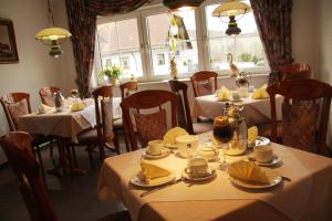 ein Restaurant mit Tischen und Stühlen mit weißen Tischdecken in der Unterkunft Hotel Edel in Haibach