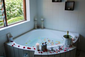a bath tub with candles and flowers in a bathroom at Rustic Butler B&B in White River +51 photos