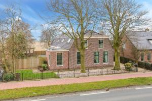 a brick house with a fence in front of a street at B&B Blossom in Lisse