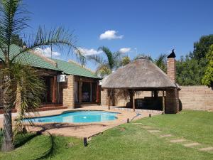 a house with a swimming pool and a gazebo at Twins Guest House Astoni in Vanderbijlpark