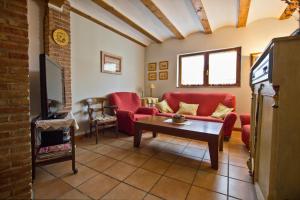 salon z czerwonymi kanapami i telewizorem w obiekcie Casa Villazón I - Camino de Santiago w mieście Muruzábal