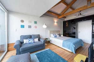 um quarto com uma cama e um sofá em Fontaínhas Stylish Apartment by DA'HOME no Porto