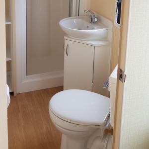 a bathroom with a white toilet and a sink at 4 Berth with private Garden - 58 Brightholme Holiday Park Brean! in Brean