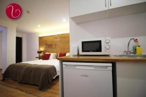 a bedroom with a bed and a tv on a counter at GuestHouse Vila Lusitania in Funchal