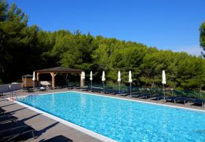 una gran piscina con sillas y sombrillas en Hapimag Apartments La Madrague en La Madrague