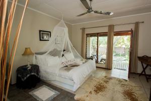a bedroom with a bed with a mosquito net at Rustic Butler B&B in White River