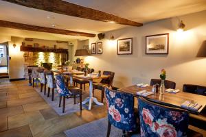 a restaurant with wooden tables and chairs and a fireplace at The Fleece at Cirencester in Cirencester