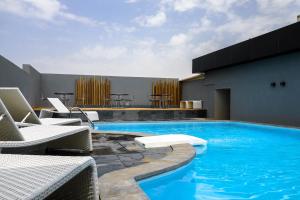 a swimming pool with lounge chairs and a building at Q Suites Jeddah by EWA - Managed by HMH in Jeddah