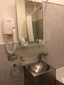 y baño con lavabo y espejo. en Albergo al Tiepolo, en Venecia