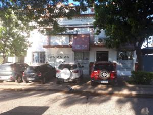 a group of cars parked in front of a building at Hotel Costanera in Formosa