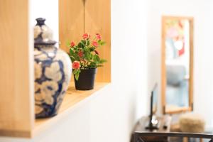 niebiesko-biała waza leżąca na półce z rośliną w obiekcie Madragoa Hideout w Lizbonie