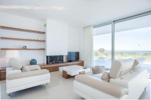 a living room with white furniture and a large window at Vila Ponta da Piedade in Lagos