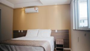 a bedroom with a bed and a window at Hotel Golden Inn Lafaiete in Conselheiro Lafaiete