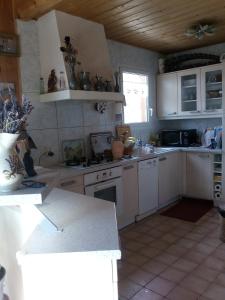 cocina con armarios blancos y encimera en Greselin en Chorges