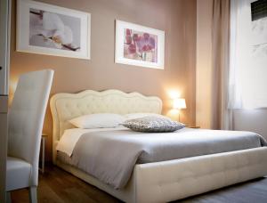 sypialnia z białym łóżkiem i białym krzesłem w obiekcie Villa di Nera B&B w mieście Palermo