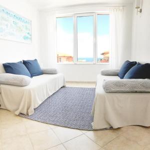 Apartament Rose في سوزوبول: سريرين مع وسائد زرقاء في غرفة بيضاء
