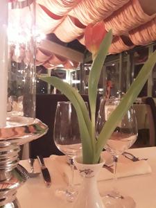 eine Blume in einer Vase auf einem Tisch mit Weingläsern in der Unterkunft Apartment da Graziella in Bad Kreuznach