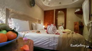 ein Schlafzimmer mit einem Bett mit einer Schale Obst auf einem Tisch in der Unterkunft Riad Gallery 49 in Marrakesch
