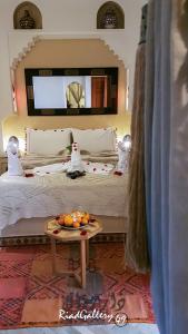 Un dormitorio con una cama y una bandeja de fruta en una mesa. en Riad Gallery 49 en Marrakech