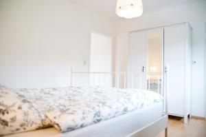 a white bedroom with a bed and a window at Zum Fuchsbau in Niederhövels