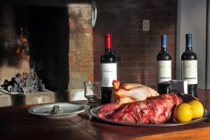 una mesa con un plato de carne y dos botellas de vino en Hotel Libertador en Santiago del Estero