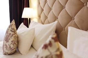a bedroom with a bed with pillows and a headboard at Suvorov Hotel in Saint Petersburg