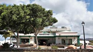 a white building with trees in front of it at B&B Hotelito el Campo in Yaiza