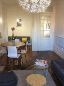 a living room with a table and chairs and a chandelier at le gambetta in Lyon