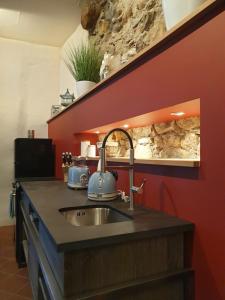 eine Küche mit einem Waschbecken und einer Steinmauer in der Unterkunft Brunnenschmiede in Konstanz