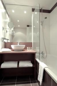 W łazience znajduje się umywalka i prysznic. w obiekcie Hôtel Le Palladior Voiron w mieście Voiron