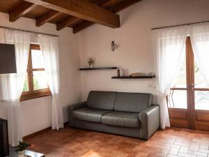 a living room with a couch and two windows at Cà del Garì in Tremosine Sul Garda