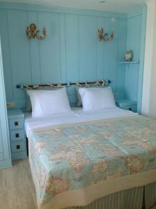 a bedroom with a large bed with blue walls at Losta Sahil Evi 2 in Selimiye