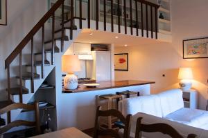 ein Wohnzimmer mit einer Treppe, einem Tisch und Stühlen in der Unterkunft Casa vacanze il Corbezzolo - Golfo di Marinella in Porto Rotondo