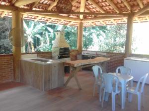eine Küche mit einem Tisch und Stühlen in einem Pavillon in der Unterkunft Sitio Da Cachoeirinha Paraju Domingos Martins in Floriano Simmer