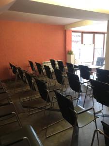 ein leeres Zimmer mit Stühlen, Tischen und einer Wand in der Unterkunft Hotel Temenuga in Panichishte