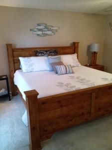 Un dormitorio con una gran cama de madera con sábanas blancas. en Bayou Beauty, en Ocean Springs
