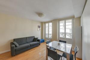 een woonkamer met een bank en een tafel bij ID 308 Châtelet Rivoli in Parijs