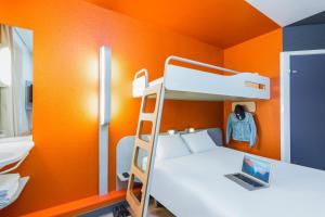 a bunk bed in a room with an orange wall at ibis budget Paris Porte De Montmartre in Paris